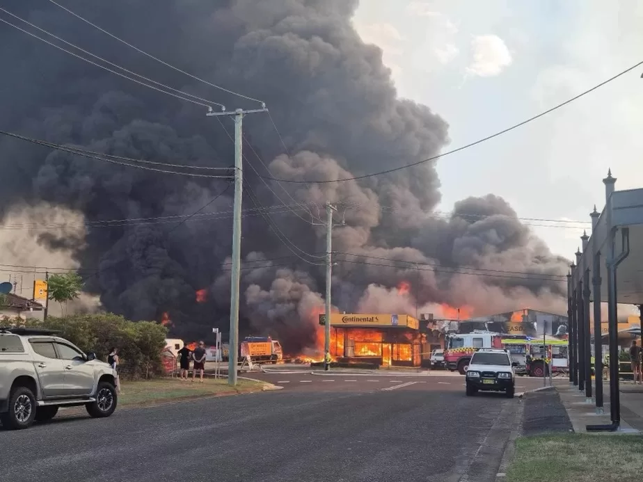 Firefighters on scene at a tyre shop alight as part of a large bushfire response.